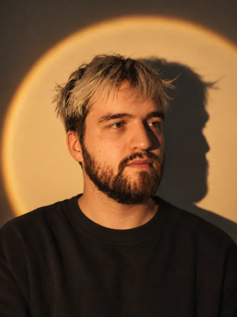 Tvardovsky, warm-lit portrait with a circular spotlight and shadow, 2026